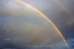 Rainbow in charcoal cloud filled sky public domain